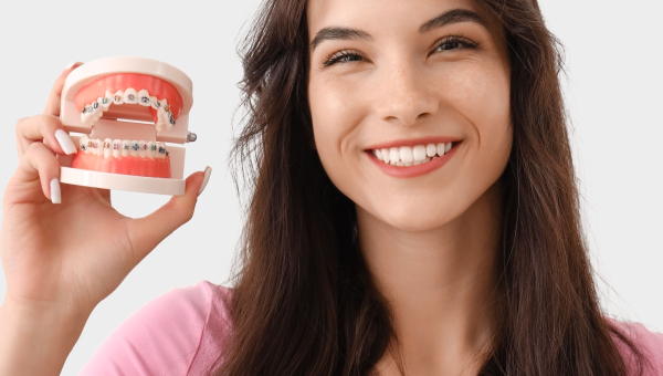 A young woman smiling while holding South Houston braces